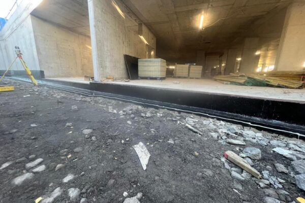 Waterproofing membrane installed at a concrete building threshold